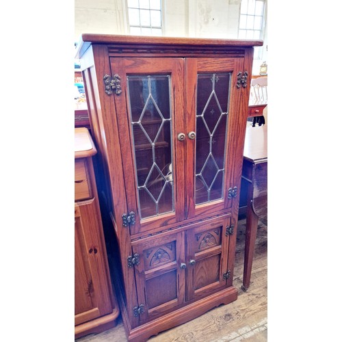 270 - An oak hi-fi cabinet with leaded glazed and carved doors