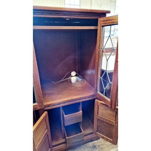 270 - An oak hi-fi cabinet with leaded glazed and carved doors