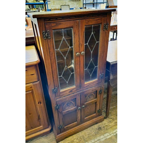 270 - An oak hi-fi cabinet with leaded glazed and carved doors