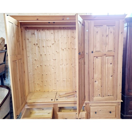 286 - Modern pine triple wardrobe with panel doors over a 3 drawer base