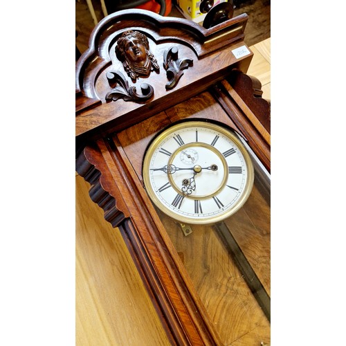 279 - Walnut and mahogany cased Vienna wall clock with mask faced finials