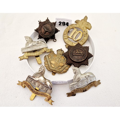 294 - Seven Lincolnshire Regiment cap badges