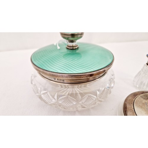 318 - Three silver and enamel lidded Art Deco dressing table jars and bottle, Birmingham 1932 in green, ma... 