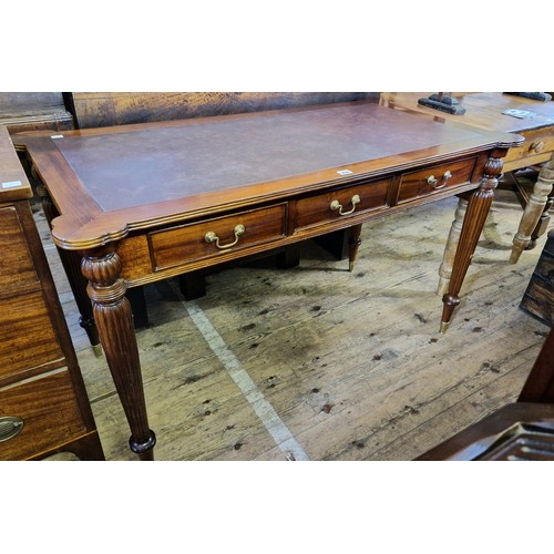 454 - Reproduction mahogany rectangular writing table with leatherette insert, three frieze drawers on tap... 