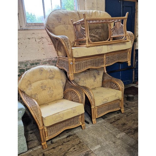 484 - Cane four-piece conservatory suite comprising settee, two chairs and glass topped occasional table