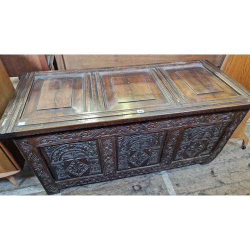 479 - Large oak 3 panel coffer with relief carved front