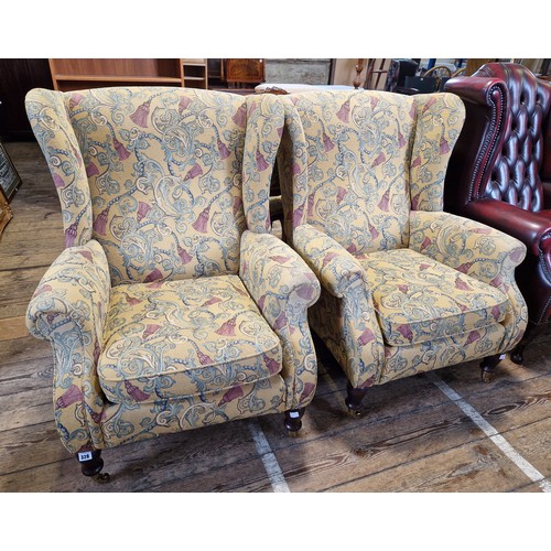 328 - Pair of modern Parker Knoll upholstered armchairs with turned mahogany legs to brass castors