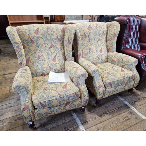 328 - Pair of modern Parker Knoll upholstered armchairs with turned mahogany legs to brass castors