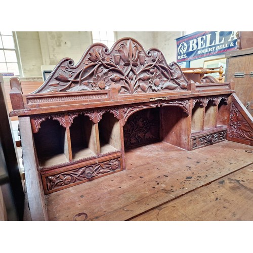 395 - Oak bureau with profuse foliate carving, carved fitted interior over a base of 7 drawers