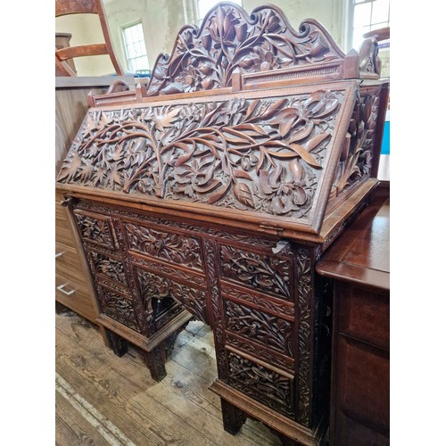 395 - Oak bureau with profuse foliate carving, carved fitted interior over a base of 7 drawers