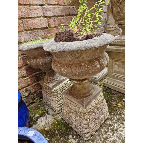 443 - Pair of simulated stone pedestal garden urns on concrete plinths