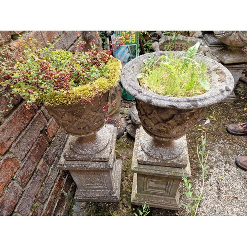 444 - Pair of simulated stone pedestal urns on classical pattern plinths