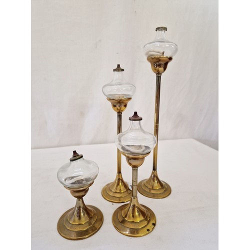 174 - Set of four brass and glass graduating oil lamps on circular pedestal bases