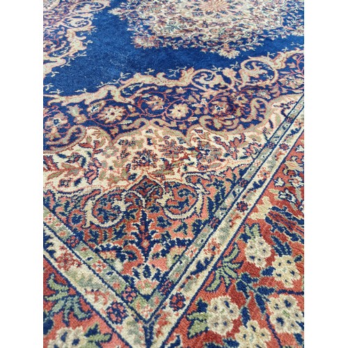 273 - Multi coloured floral woollen rug on blue ground approx. 230cm x 140cm