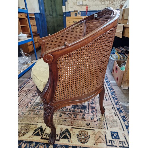 293 - Reproduction mahogany framed rattan panelled tub chair with foliate carving and serpentine stretcher