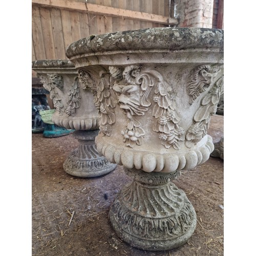 462 - Pair of simulated stone pedestal urns with lions mask and swag relief