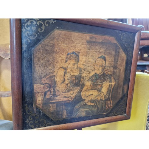 361 - Victorian mahogany pole screen with painted panel of figures in a rustic interior on turned baluster... 