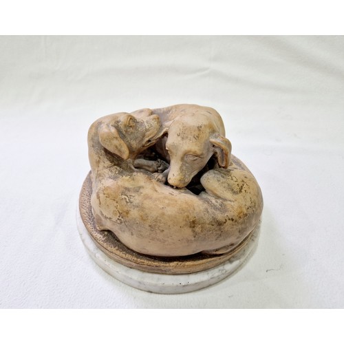 79 - A terracotta group of two pups at play on a circular white marble plinth, signed 'J. Gott FT' on the... 