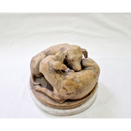 79 - A terracotta group of two pups at play on a circular white marble plinth, signed 'J. Gott FT' on the... 