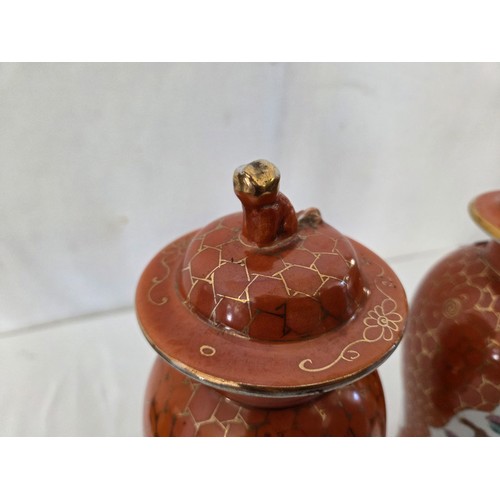 25 - Pair of Japanese covered baluster jars with panels of dragons and birds on an orange and gilt ground