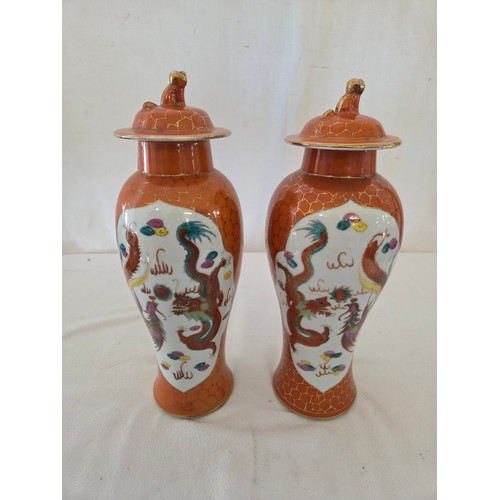25 - Pair of Japanese covered baluster jars with panels of dragons and birds on an orange and gilt ground