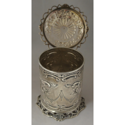 4 - A silver cylindrical container, London 1896, maker George Maudsley Jackson, with hinged lid and embo... 