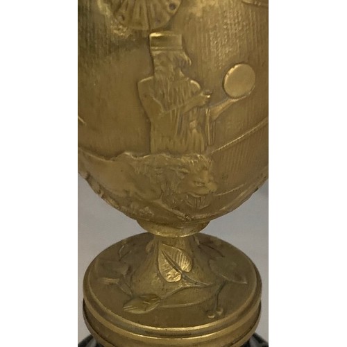 33 - A gilt brass Romanesque urn, 19th century, decorated with seven figures and a lion in high relief, s... 