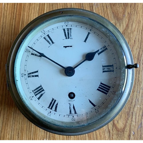34 - A circular brass ship's clock, the 14 cm white enamel dial  with Roman numerals and marked Elliott, ... 