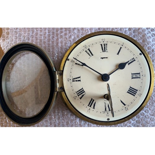 34 - A circular brass ship's clock, the 14 cm white enamel dial  with Roman numerals and marked Elliott, ... 