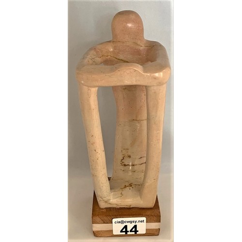 44 - A standing human-like figure, carved in alabaster, in the manner of Henry Spencer Moore, 24 cm high.