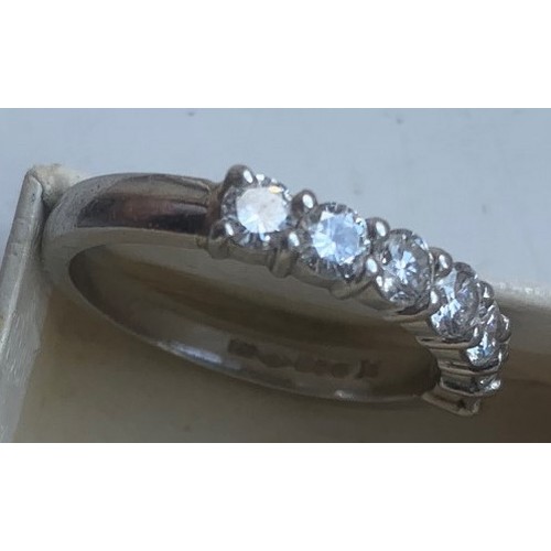 56 - A platinum and diamond ring, the seven bright cut diamonds separated by raised spacers, hallmarked f... 