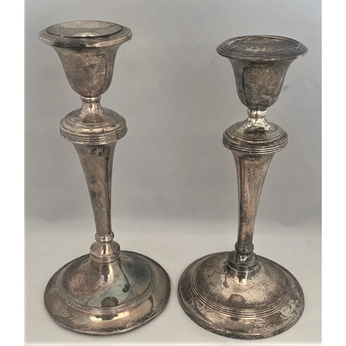 126 - A matched pair  of silver cased candlesticks, by Williams,  Birmingham 1908 and 1909, with loaded ba... 