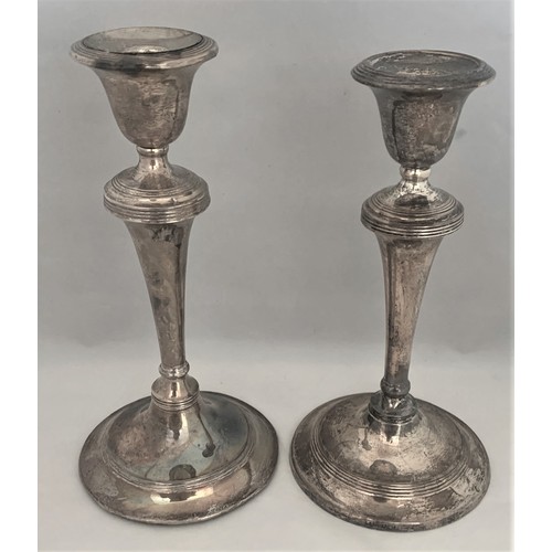 126 - A matched pair  of silver cased candlesticks, by Williams,  Birmingham 1908 and 1909, with loaded ba... 