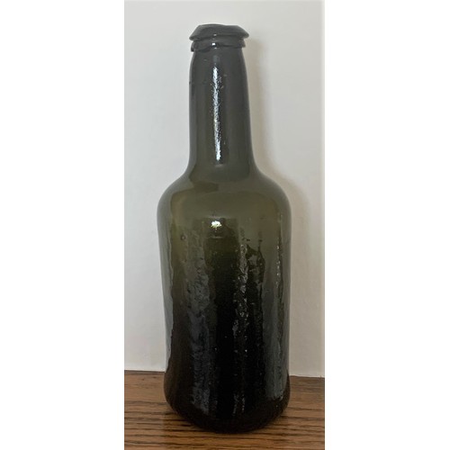 37 - Free blown green glass wine bottle, with applied lip and deep kick to base, 26 cm high.