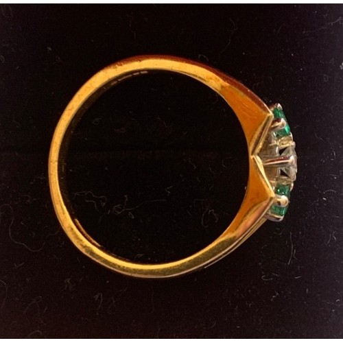 129 - An 18 carat yellow gold, Diamond and Emerald ring, size M.