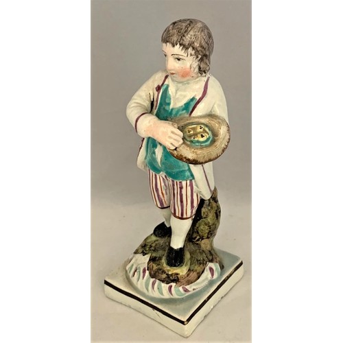 9 - Pottery figure, Staffordshire, early 19th century, with painted decoration, depicting a boy with bir... 