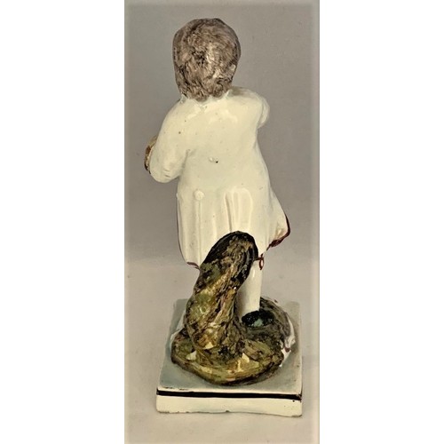 9 - Pottery figure, Staffordshire, early 19th century, with painted decoration, depicting a boy with bir... 