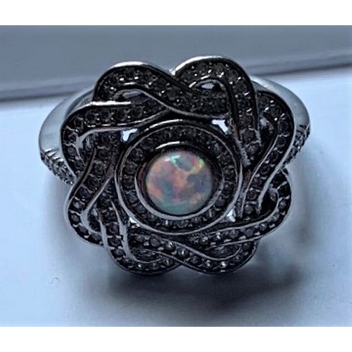 111 - Silver and cubic zirconia ring with central opal panel.