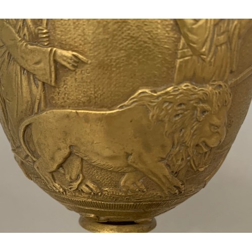 51 - A gilt brass Grand Tour style chalice, 19th century, decorated with seven figures and a lion in high... 