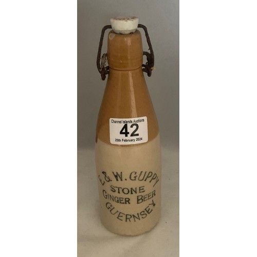 42 - Stoneware two tone bottle with black transfer, 'E. & W. Guppy Stone Ginger Beer Guernsey' with metal... 