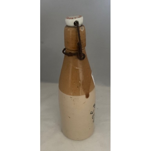 42 - Stoneware two tone bottle with black transfer, 'E. & W. Guppy Stone Ginger Beer Guernsey' with metal... 