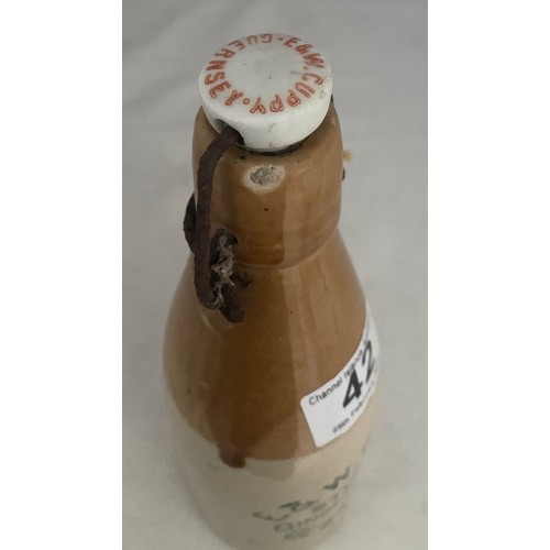 42 - Stoneware two tone bottle with black transfer, 'E. & W. Guppy Stone Ginger Beer Guernsey' with metal... 