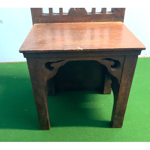 4 - A child's miniature Gothic style oak chair, 56cm wide, 21cm high.