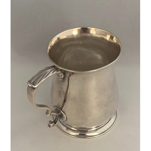 34 - A silver tankard, early 19th century, with indistinct hallmarks, of plain baluster form with acanthu... 