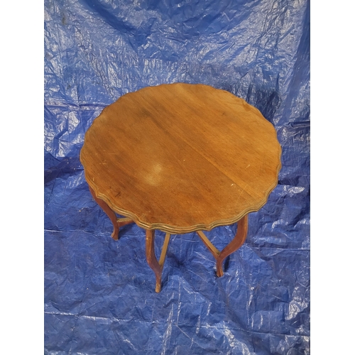 4 - AN EDWARDIAN MID-MAHOGANY ROUND OCCASIONAL TABLE WITH BOWED LEGS AND
SCALLOPED EDGING. 75 CM X 75 CM... 