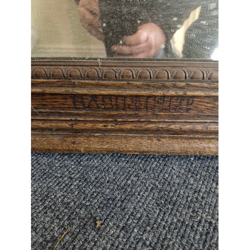 54 - A nice sized and heavy mirror in a solid oak frame.. marked Bass and Co.