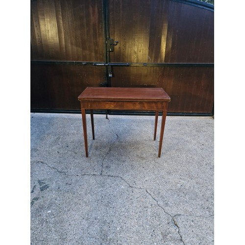 165 - An Edwardian folding card table on tapered legs.