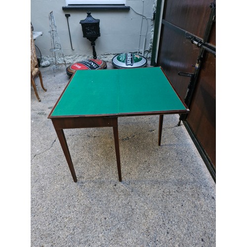 165 - An Edwardian folding card table on tapered legs.