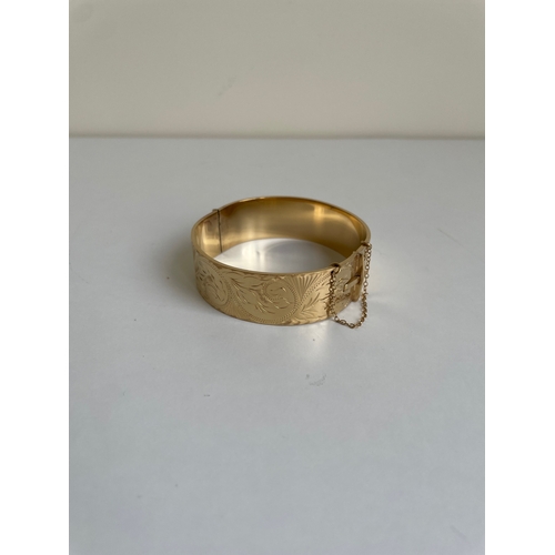 16 - A gold clasped bangle bracelet. Gold plated with bronze core.