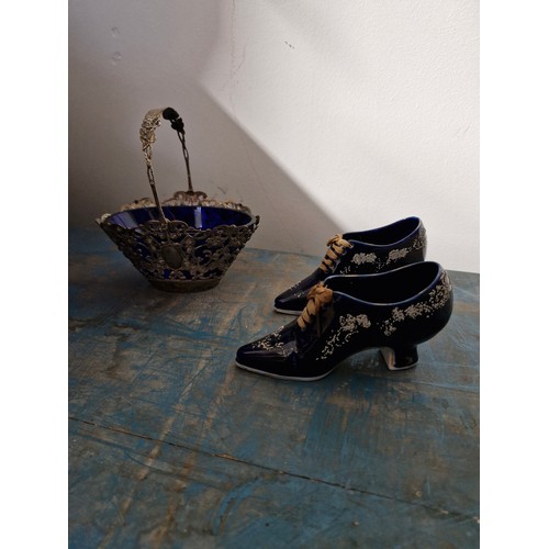 122 - Two porcelain shoes and a silver plated basket with blue glass.